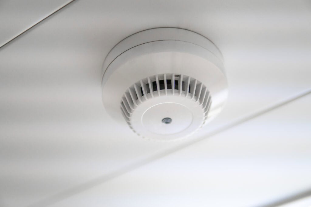 Close-up of a white security camera mounted on a ceiling, designed for surveillance and safety monitoring in residential or commercial spaces.