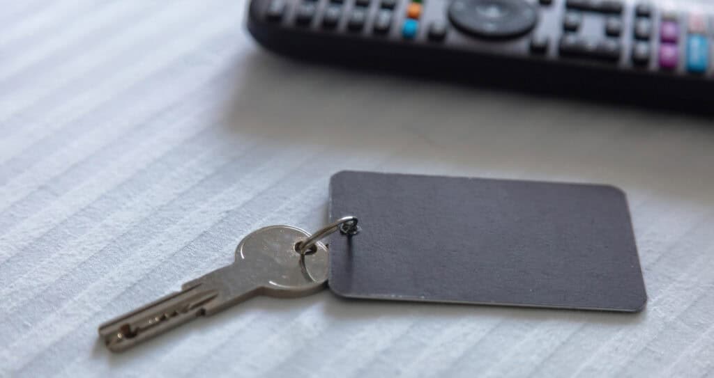 Close-up of a key with a black access card on a light-colored surface, illustrating workplace security access systems.