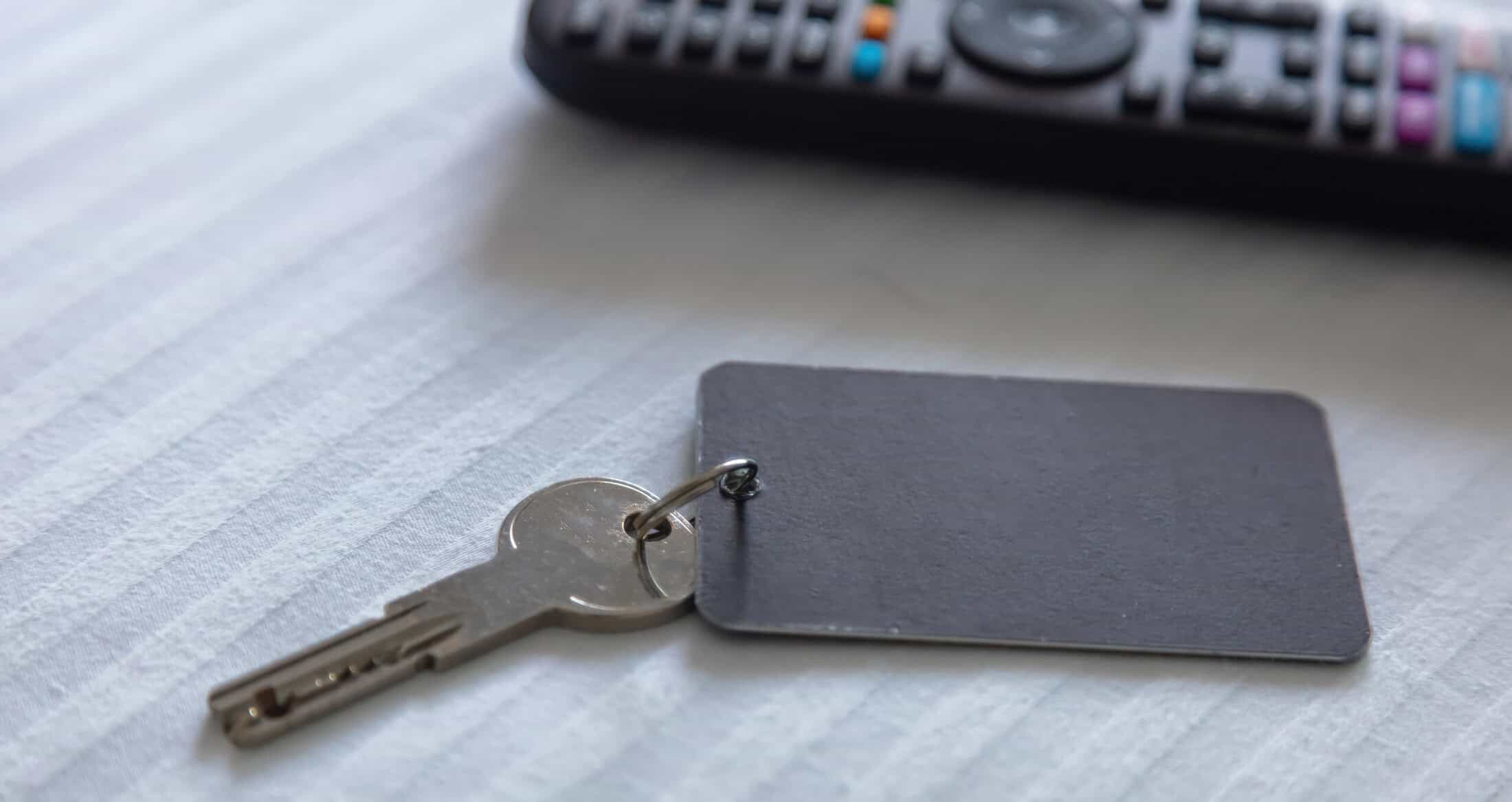 Close-up of a key with a black access card on a light-colored surface, illustrating workplace security access systems.