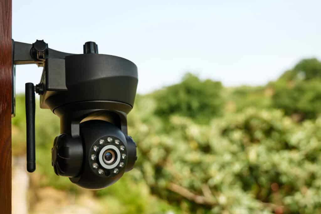 Outdoor pan-tilt security camera mounted on building with night vision and motion detection for video surveillance system