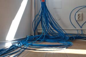 Cables Blue network cables organized on the floor near electrical outlets, illustrating commercial pre-wiring services in Chicago.